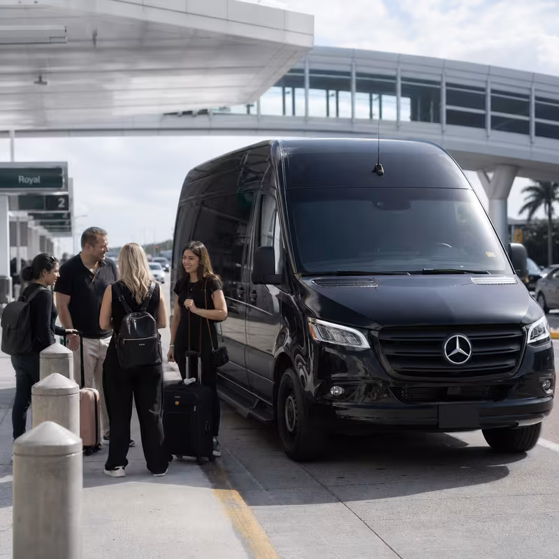 Group boarding a white charter bus for Airport Transportation transportation in Miami