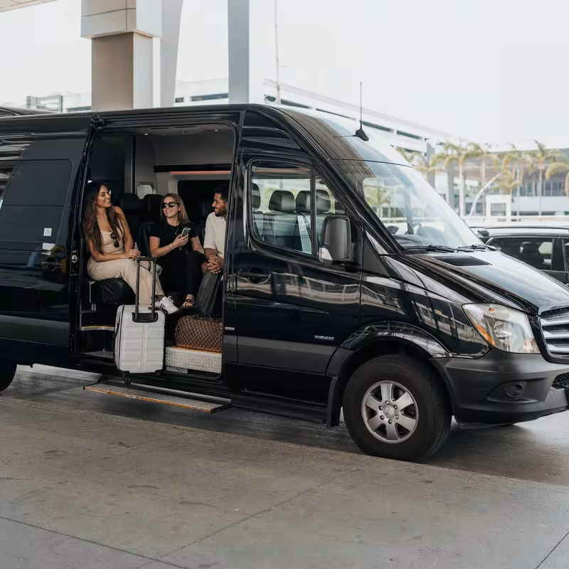 Passengers loading luggage while boarding a Miami group shuttle