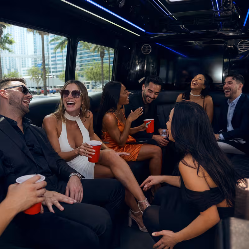 Party bus interior with wraparound leather seating and LED lighting in Miami