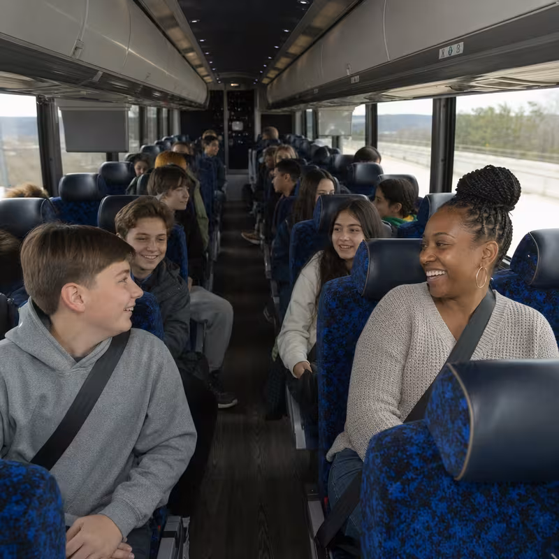 Group boarding a white charter bus for School Transportation transportation in Miami