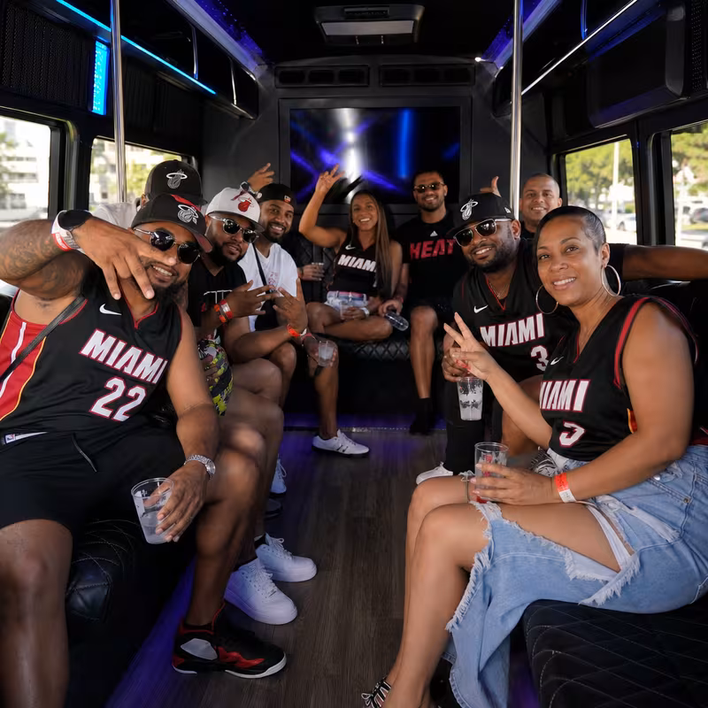 Group boarding a white charter bus for Sporting Event Transportation transportation in Miami
