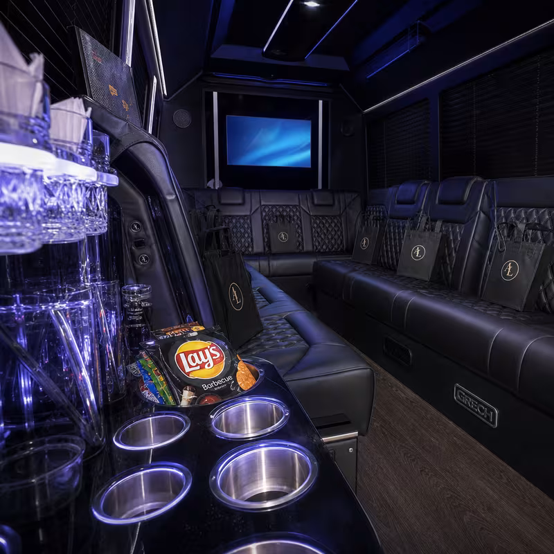 Party bus interior with wraparound leather seating and LED lighting in Miami